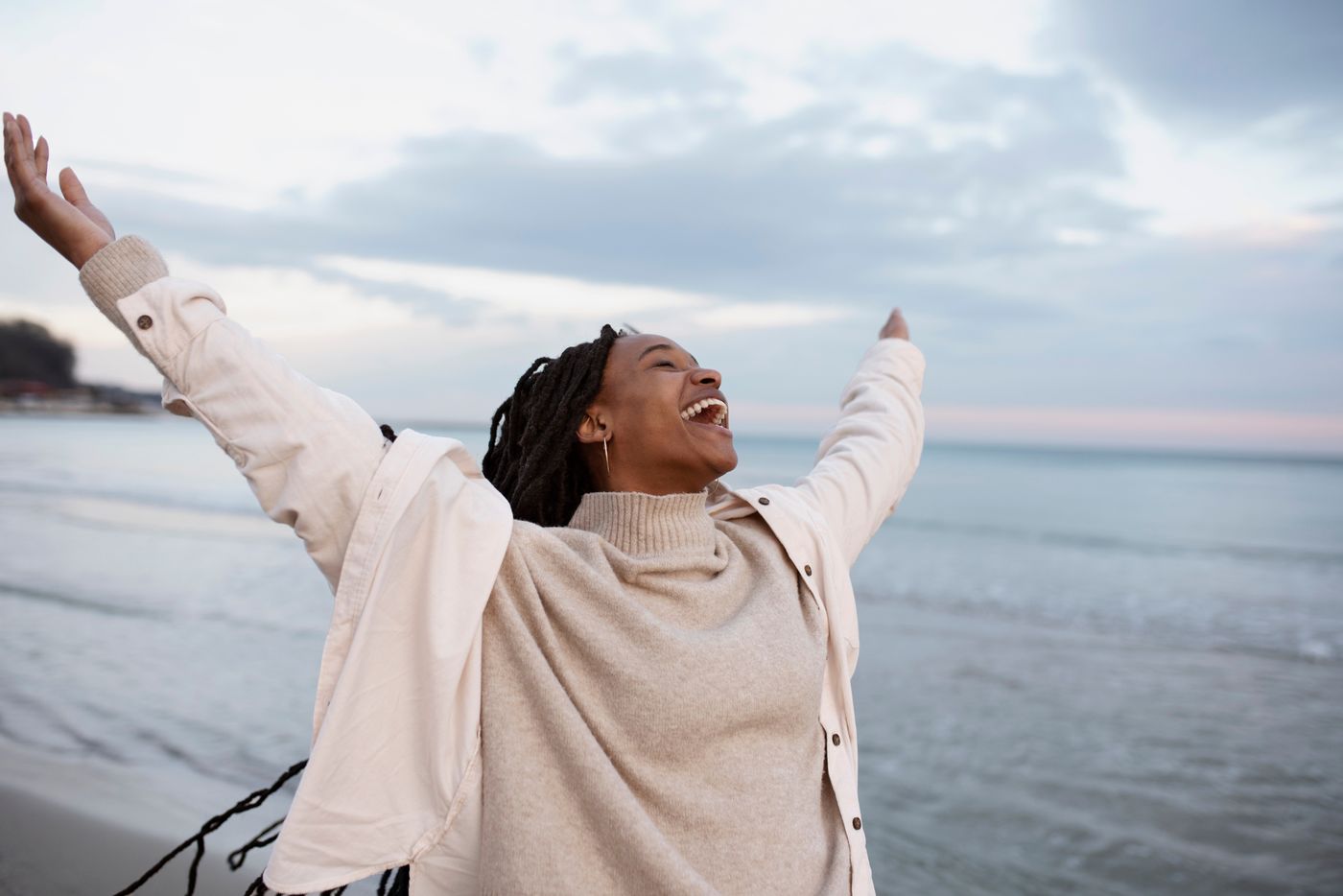 Woman joyfully raising her arms on the beach
